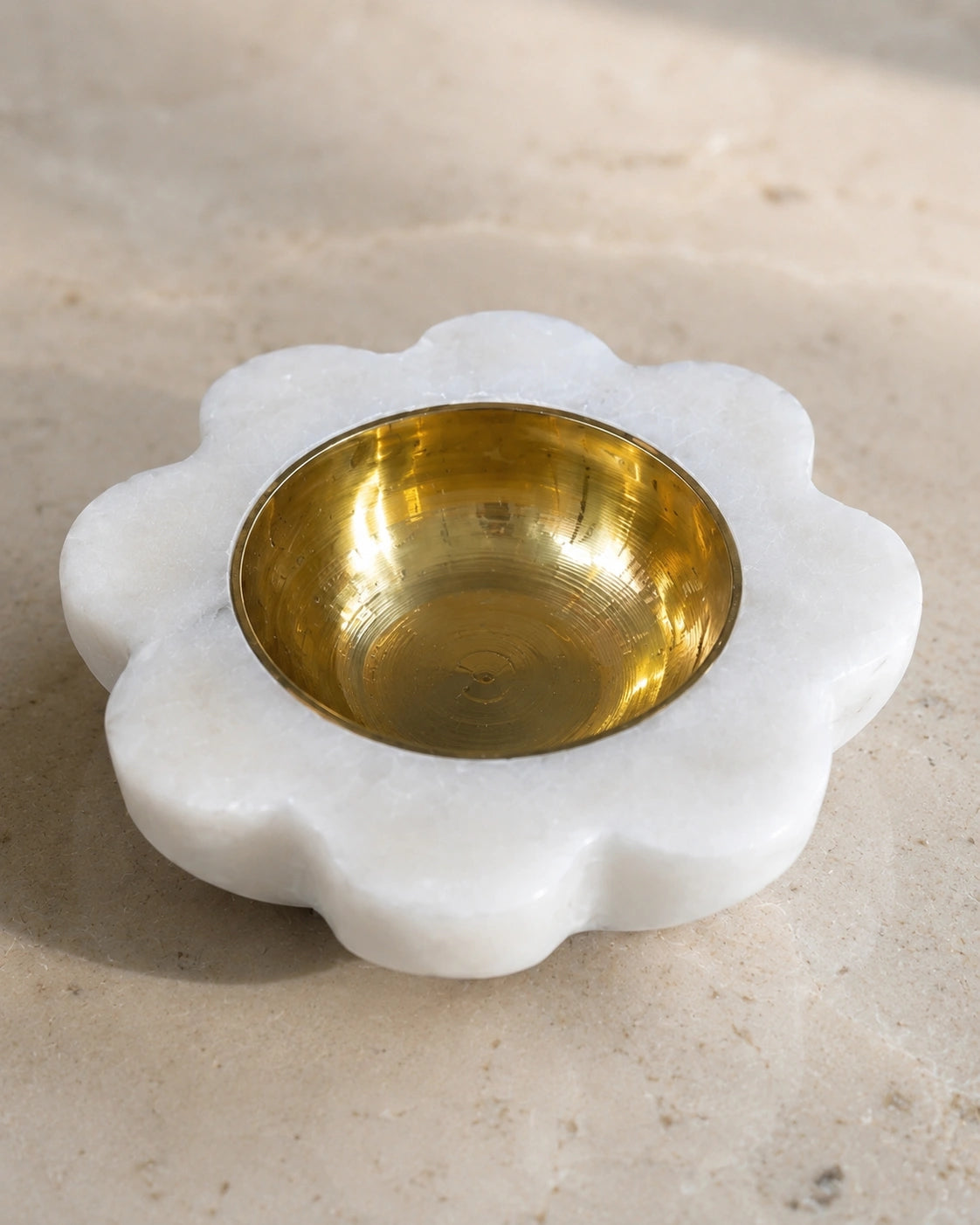 white marble flower diya with brass oil container lit for daily home puja ritual