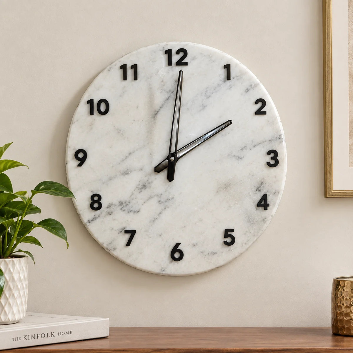 White marble wall clock with black raised numerals and elegant black hands by Reggal Decors, perfect for modern living room and home décor.