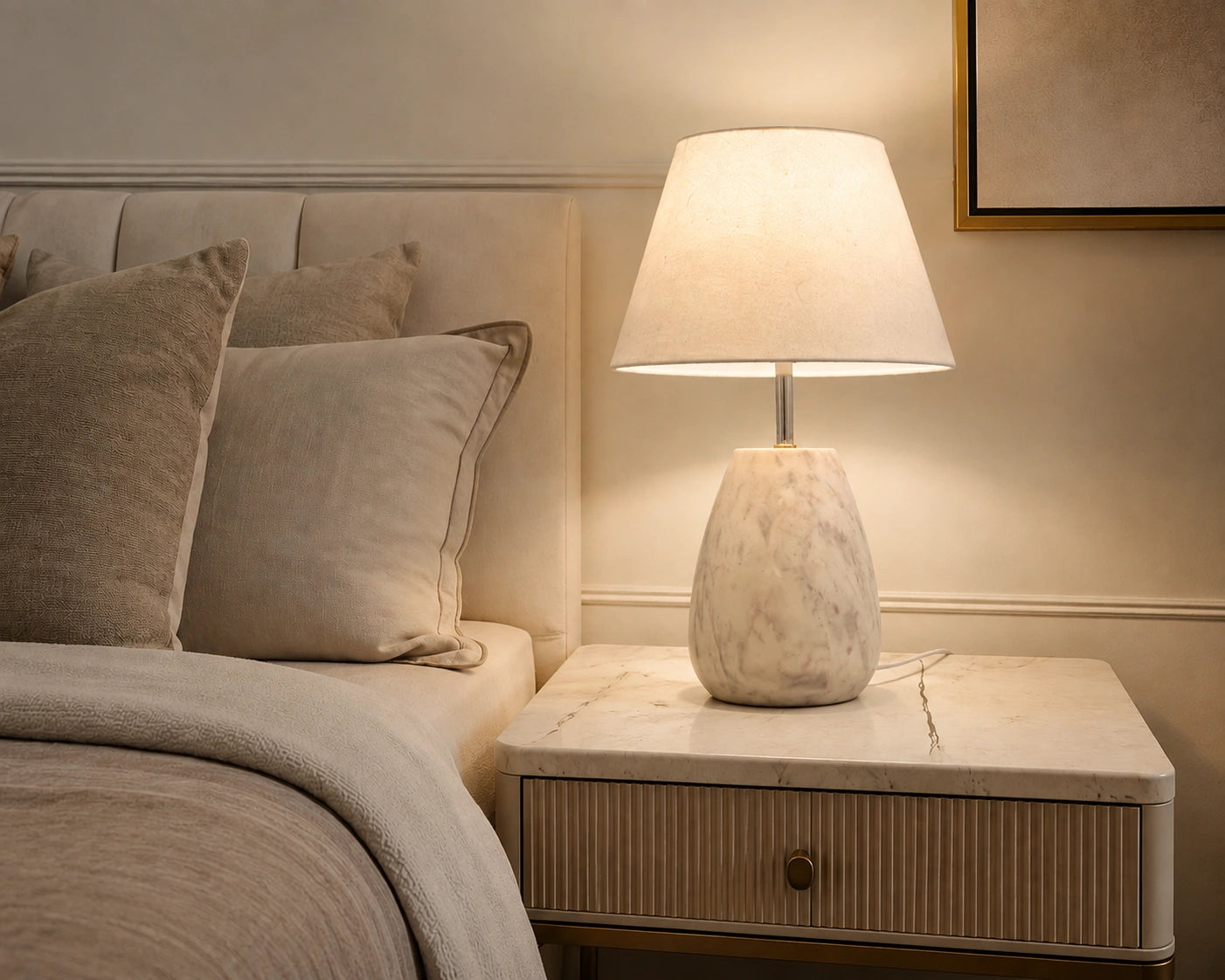 White stone-look decorative table lamp styled on a bedroom bedside table