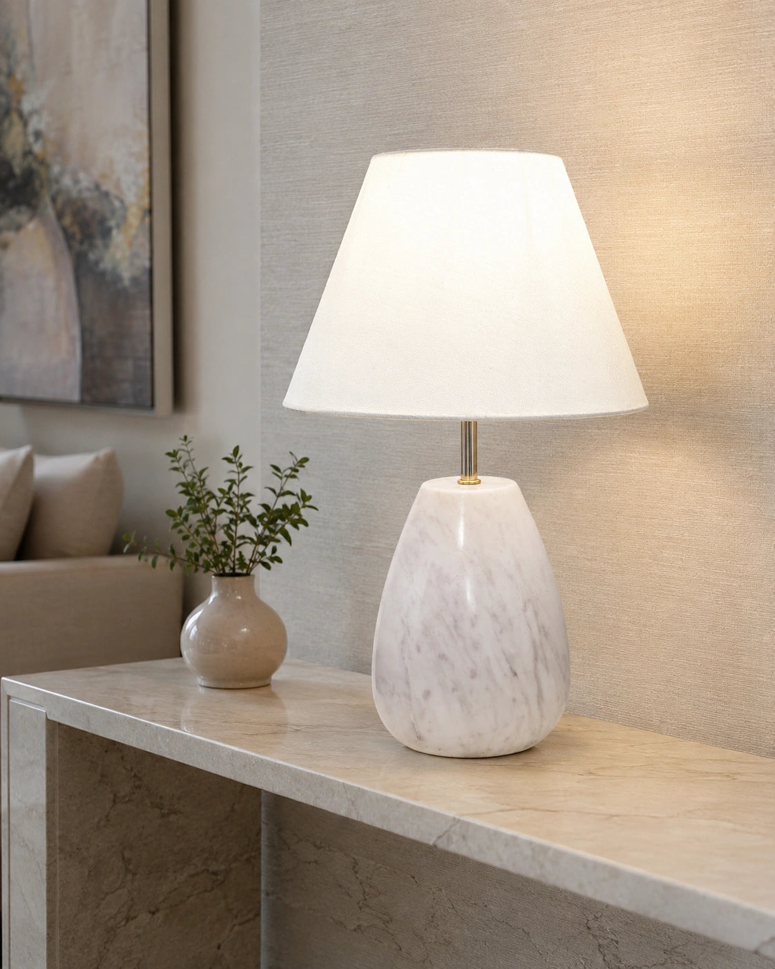 White stone-look table lamp with gold-tone detailing styled on a living room console table